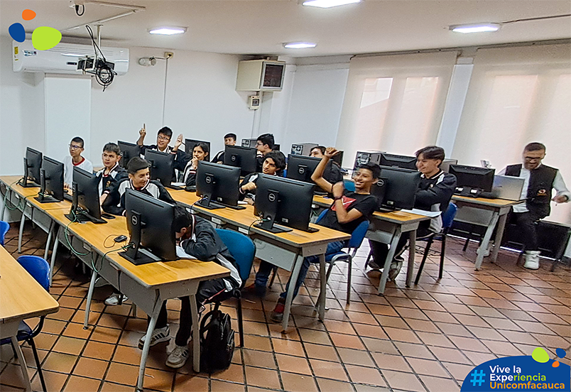 Estudiantes de 10º y 11º en una sala de sistemas participando mientras se les capacita en programación de robots y diseños mecatrónicos. 