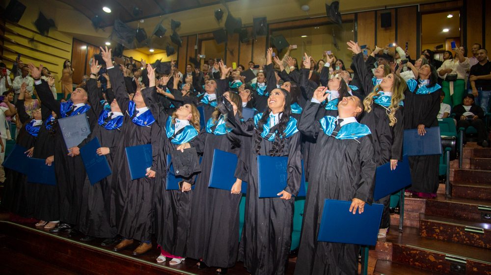 Foto grupal de los graduados de la Facultad de Ciencias Empresariales lanzando los birretes.